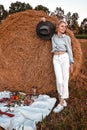 Woman in cowboy hat staying near a straw bale. Summer, beauty, fashion, glamour, lifestyle concept. Cottagecore farmcore Royalty Free Stock Photo