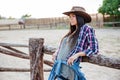 Woman cowgirl in hat and plaid shirt standing outdoors Royalty Free Stock Photo