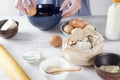 Woman cracking an egg into the blue bowl, baking cake process.Base ingredients for baking on the kitchen table Royalty Free Stock Photo