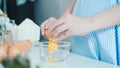 Woman cracking an egg into a bowl with standing by in kitchen. Royalty Free Stock Photo