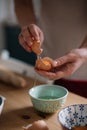 Woman cracking the eggs in a bowl