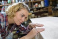 Woman craftsperson working on workbench in workshop