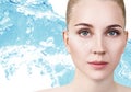Woman with cream dots on face in blue water splash Royalty Free Stock Photo
