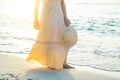 Woman in a cream dress is walking, enjoying the beautiful sunset Royalty Free Stock Photo