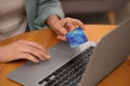 Woman with credit card using laptop for online shopping at wooden table, closeup Royalty Free Stock Photo