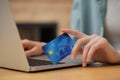 Woman with credit card using laptop for online shopping at wooden table, closeup Royalty Free Stock Photo