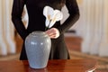 Woman with cremation urn at funeral in church