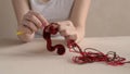 Woman crocheting with red and brown yarn