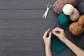 Woman crocheting with teal thread at grey wooden table, top view. Space for text Royalty Free Stock Photo