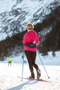 Woman cross country skiing at the foothill of mountain peaks, wide shot