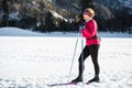 Woman cross country skiing at the foothill of mountain peaks, wide shot Royalty Free Stock Photo