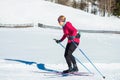 Woman cross country skiing at the foothill of mountain peaks, wide shot Royalty Free Stock Photo