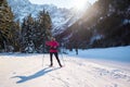 Woman cross country skiing at the foothill of mountain peaks, wide shot Royalty Free Stock Photo
