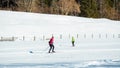 Woman cross country skiing at the foothill of mountain peaks, wide shot Royalty Free Stock Photo