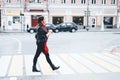 Woman crosses the road with a hot drink. Royalty Free Stock Photo