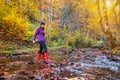 Woman crosses a stream in rubber boots Royalty Free Stock Photo