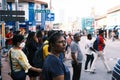 Woman crossing a busy city street with a diverse crowd of people in the background