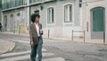 Woman crossing city road holding cup coffee. african american lady walking town. Royalty Free Stock Photo