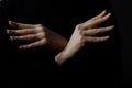 Woman crossing hands forming bird wings isolated on black background Royalty Free Stock Photo