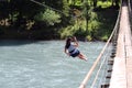 Woman crossing a river with tyrolean traverse Royalty Free Stock Photo