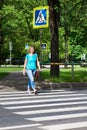 Woman crossing street at pedestrian crossing Royalty Free Stock Photo