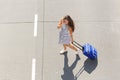 Woman crossing street with suitcase talking on mobile phone Royalty Free Stock Photo