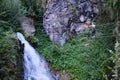 Woman crossing the suspended wire bridge towards Talbach waterfall, on a via ferrata route in Zillertal valley, Austria Royalty Free Stock Photo