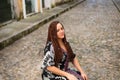 A woman crouched down on a cobbled street