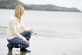 Woman crouching on beach Royalty Free Stock Photo