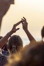 Woman in the crowd claps with hands up