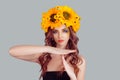 Woman in crown from sunflowers making a timeout gesture