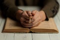 Woman with crucifix in her hands is reading the Bible. Learning the gospel and Catholicism