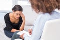 Woman crying on sofa while therapist is taking notes Royalty Free Stock Photo