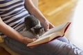 Woman cuddling kitten and reading a book Royalty Free Stock Photo