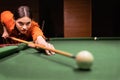 Woman with cue aiming at billiard ball at table, gambling. American pool billiard. Fragment of the pool billiard game in Royalty Free Stock Photo