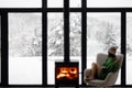 Woman with cup on chair by the fireplace at house on nature