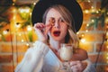 Woman with cup of coffee, cookie and Christmas lights Royalty Free Stock Photo