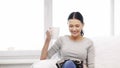 Woman with cup of coffee reading magazine at home