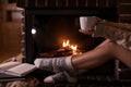 Woman with cup of hot cocoa near fireplace indoors Royalty Free Stock Photo