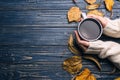 Woman with cup of hot drink at blue wooden table, top view with space for text. Cozy autumn atmosphere Royalty Free Stock Photo