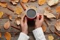 Woman with cup of hot drink at wooden table. Cozy autumn atmosphere Royalty Free Stock Photo