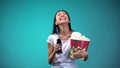 Woman with cup of popcorn and soda sincerely laughing watching comedy, fun