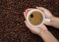 Woman with cup of tasty espresso and roasted coffee beans, top view. Space for text Royalty Free Stock Photo