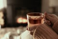 Woman with cup of tea resting near fireplace at home, closeup Royalty Free Stock Photo