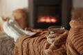 Woman with cup of tea resting near fireplace at home, closeup Royalty Free Stock Photo