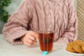 Woman with cup of tea at wooden table, closeup Royalty Free Stock Photo