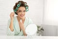 Woman With Curlers Applying Mascara Looking At Mirror At Home Royalty Free Stock Photo