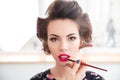 Woman in curlers with makeup made by professional visagist