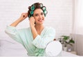 Woman Curling Hair Using Curlers Sitting At Mirror At Home Royalty Free Stock Photo