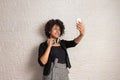 Woman with curly afro hair taking photos on mobile smart phone. Technology, social media, connection concept Royalty Free Stock Photo